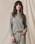 Gray Long Sleeve Slim Tee by The Great Inc. styled with sweatpants, shown against a neutral fabric backdrop.