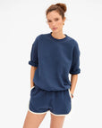 Navy Clare Vivier Le Jogging Shorts with elastic waistband and side pockets, styled with a blue sweatshirt.