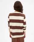 Person with long wavy hair shown from the back wearing Clare Vivier's LS Rugby Stripe Tee in brown and beige stripes with a brown skirt, set against a plain white background.
