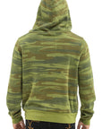 Person seen from behind wearing the Aviator Nation 5 stripe - zip hoodie in green camo with solid green hem and cuffs for a vintage look, hood up, paired with dark jeans.