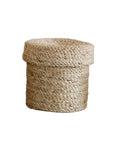 The Faire Round Lidded Jute Basket is a small, round storage basket with a matching lid, crafted from natural jute fibers and shown against a white background.