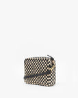 The Midi Sac S25 by Clare Vivier is a small rectangular crossbody bag featuring a black and beige checkerboard pattern, gold hardware, handwoven leather accents, and a thin black detachable strap, shown on a white background.
