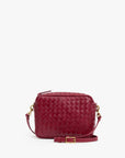 Small garnet handwoven leather crossbody bag with gold hardware and detachable strap by Clare Vivier.