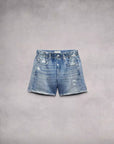 The Rag & Bone Miramar Walking Short features a classic blue denim look with faded, distressed details and a subtle denim print. Light fraying accents the edges, complemented by belt loops, a front zipper, and pockets, showcased against a neutral backdrop.