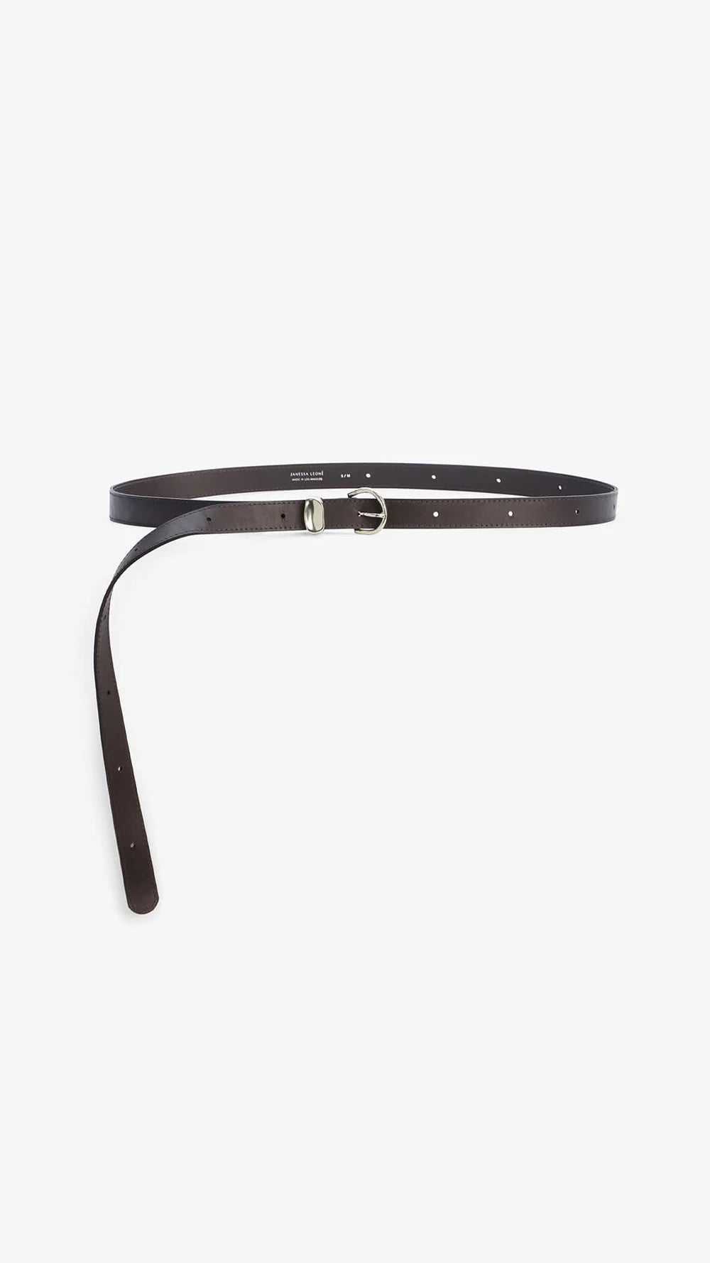 The Janessa Leone Myra DW Belt is crafted from dark brown regenerative leather and finished with artisan silver hardware. It’s shown flat, with one end through the buckle and the other end trailing.