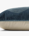 A close-up side view of the Loloi Rugs PBR0004 Navy Pillow shows its rectangular shape, blue textured cotton top with a curved embroidered pattern, beige bottom, and discreet zipper along one edge.
