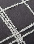 Close-up of the Loloi Rugs PJS0012 Graphite/Ivory Pillow 13x35, showing dark gray fabric with a textured white grid and knife edge finish, featuring raised intersecting lines for a simple, modern look.