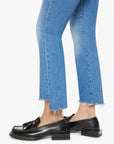Cropped view of a person wearing Mother’s Lil Insider Crop Step Fray jeans and black leather loafers with tassel details, standing against a white background.