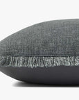 Close-up of the Loloi Rugs Sable Blue 22x22 pillow: a rectangular, dark gray machine-woven cushion in textured polyester-cotton-linen blend with fringe trim and hidden flap zipper, shown against a plain white background.