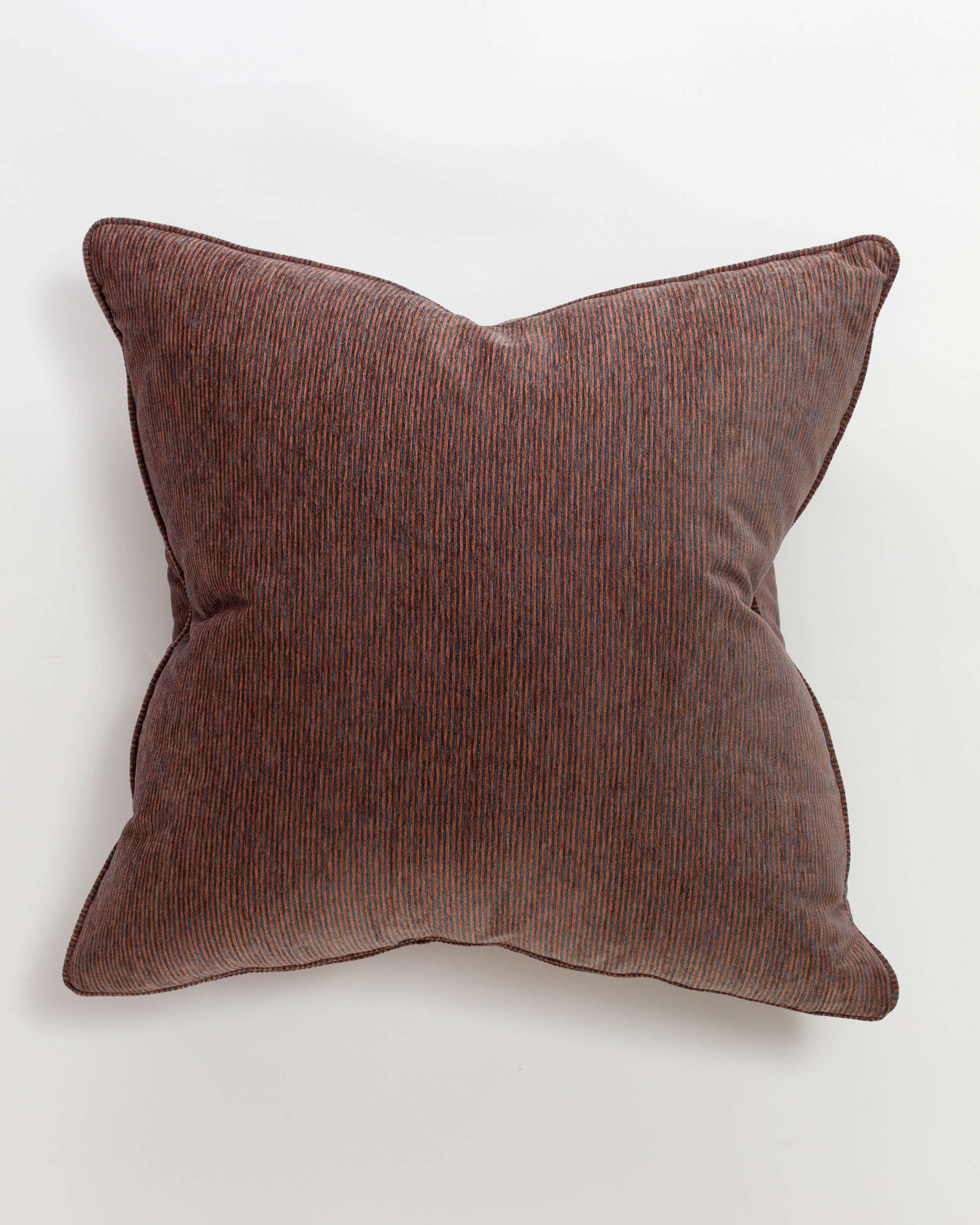 The Massoud Hinsdale Patina Pillow is a 26x26" square cushion in brown corduroy with subtle dark vertical stripes, offering an ultra-luxurious euro pillow-like feel. It is showcased elegantly against a plain white background.