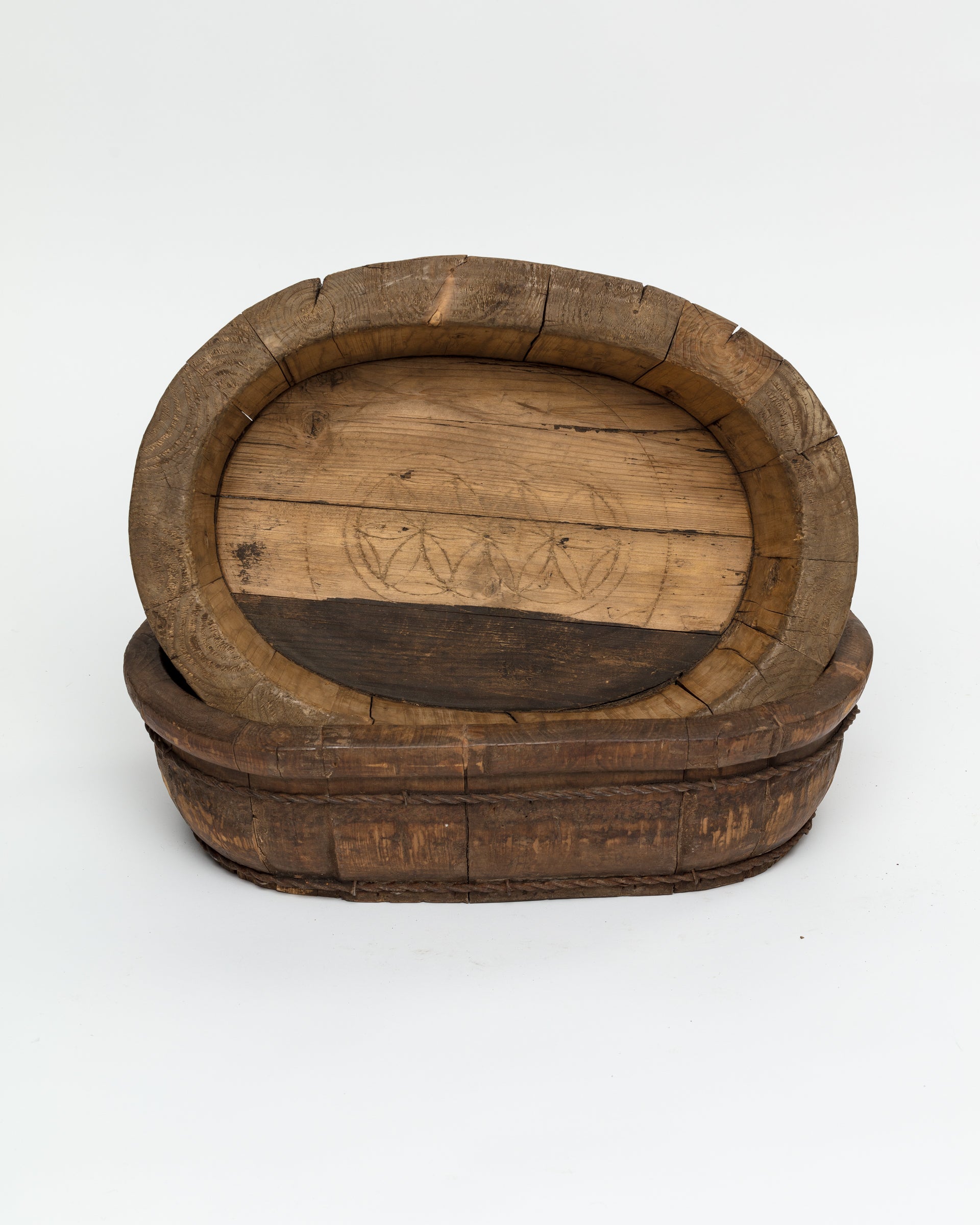 An oval-shaped, vintage Oval Wood Bucket 10 from a Scottsdale Arizona bungalow with visible wear and carved patterns on a plain white background. Brand: Indus Design Imports.