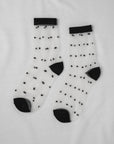 Sheer Dot Socks by Unified: sheer white socks with small black dots and contrasting black cuffs, heels, and toes—an ideal playful touch for any outfit.