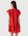 A woman with long brown hair is seen from the back wearing the Sea New York Pippa SS Mini Dress—a bright red, loose-fit mini with lace accents on the sleeves, hem, vertical seams, and ruffled trim at the bottom.