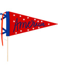The My Mind's Eye Felt Pendant Banner features "America" in blue cursive with white stars on red felt, attached to a wooden stick with blue, white, and red ribbon streamers—perfect for showing your patriotic spirit.