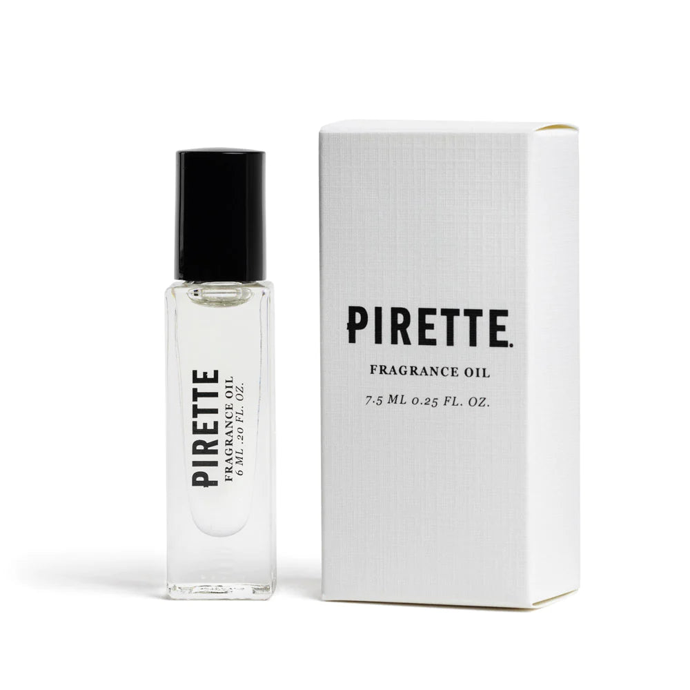 A glass bottle of Pirette Mini Fragrance Oil with a rollerball applicator next to its white packaging box on a plain white background. The bottle contains clear oil and is labeled with the brand name and product details.