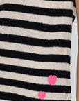 The Lisa Todd Summer Lovin Sweater is a black and beige striped sleeveless crew neck tank, featuring two small pink crochet hearts near the bottom hem. Only part of the model's arm and torso are visible.