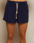 A person models the Perfectwhitetee Summer Loop Terry Sweat Shorts in navy blue, standing against a light background, shown from waist to just below the knees.