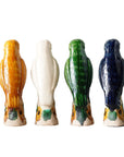 Four "Parrot Small" ceramic figurines by Blue Ocean Traders, inspired by Jingdezhen hand-painted porcelain, are painted in yellow, white, green, and blue and arranged in a row facing away on a white background.