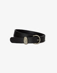 The Janessa Leone Myra belt, crafted from black leather and finished with a rounded silver buckle, is showcased coiled on a simple white background.