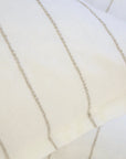 A close-up of two overlapping Blake Big Pillows 28x36 from POM POM, showcasing sophisticated stripes with vertical, thin beige lines that form a simple and elegant pattern.