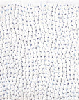 Close-up of a John Robshaw Coverlet King with a densely knotted white and pale blue pattern, evocative of the intricate designs found in Scottsdale Arizona bungalows, creating a detailed and nuanced surface.