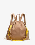 The Clare Vivier Sac Tout Backpack is a tan recycled nylon bag with dual top handles, a yellow adjustable shoulder strap, gold hardware, and a small yellow tag.