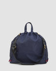 Large navy tote with black crossbody strap, gold hardware, and red accents by Clare Vivier.