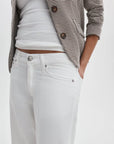 Wearing a white ribbed tank, brown and white checkered blazer, and Rag & Bone ftwt saige full straight jeans in white, the person poses with one hand in their pocket. The image is cropped from shoulders to thighs.