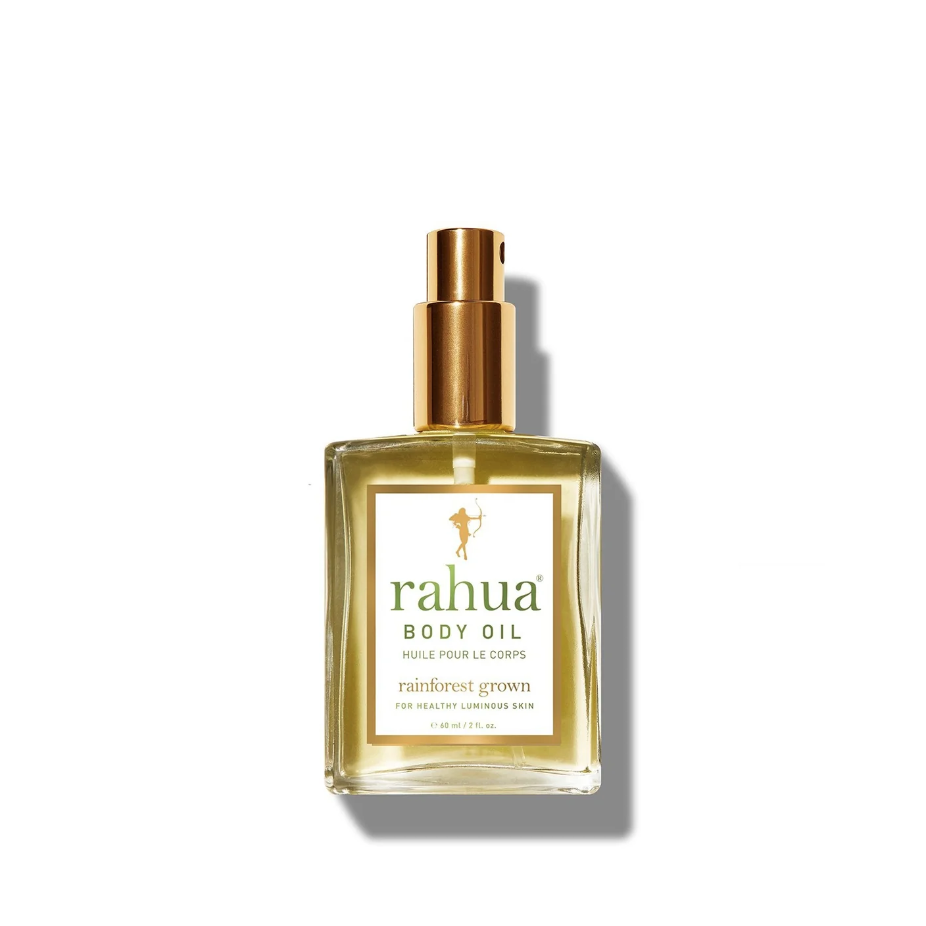 A glass bottle of Faire body oil with a golden cap, centered on a white background. The label reads &quot;Rainforest Grown Beauty&quot; and &quot;For Radiant Luminous Skin,&quot; sourced from the bungalow gardens of Scottsdale, Arizona.