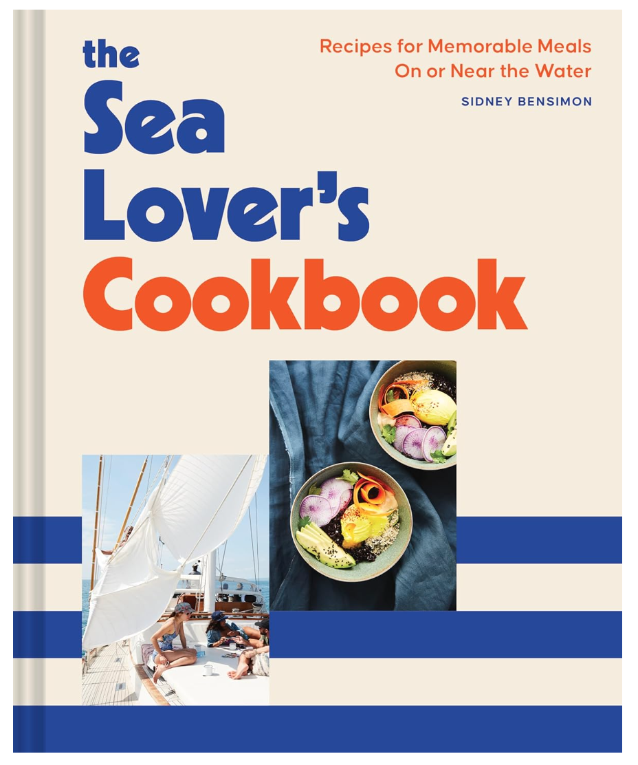 Cover of the Sea Lover's Cookbook by Hachette Book Group featuring dishes in bowls, a sailboat, against a bungalow-style white and blue striped background.