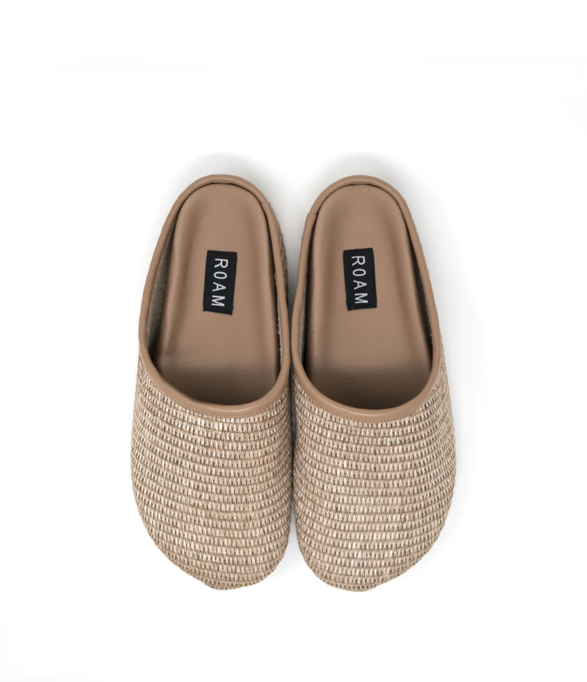 A pair of beige, Roam the Raffia Clog slip-on shoes with a woven exterior, seen from above on a white background. The shoes have the word &quot;ROAM&quot; printed on the insoles and are inspired by the relaxed lifestyle of Scottsdale, Arizona.