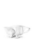 A white porcelain Gravy Boat No. 151 by Montes Doggett with a unique bungalow-inspired design that looks like a cow, featuring legs as the base and a tail-shaped handle, on a white background.