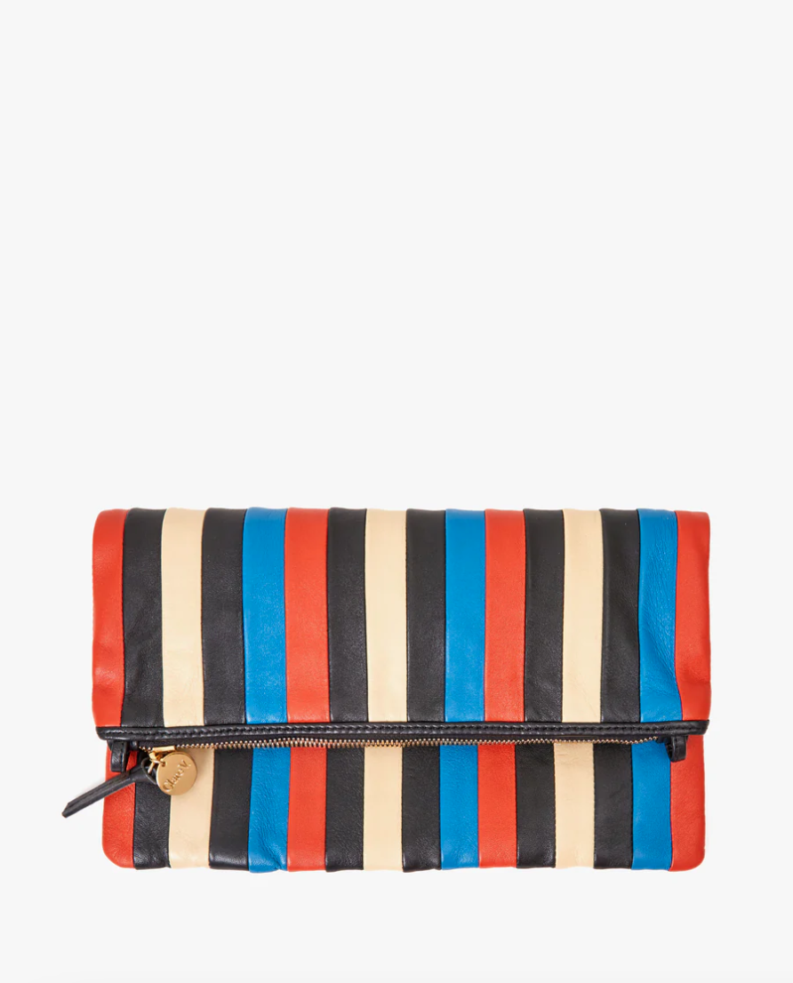 Multicolored striped Foldover Clutch w/ Tabs Multi Stripes Nappa with a zip closure, featuring bold red, blue, black, and cream stripes in a bungalow style on a white background by Clare Vivier.