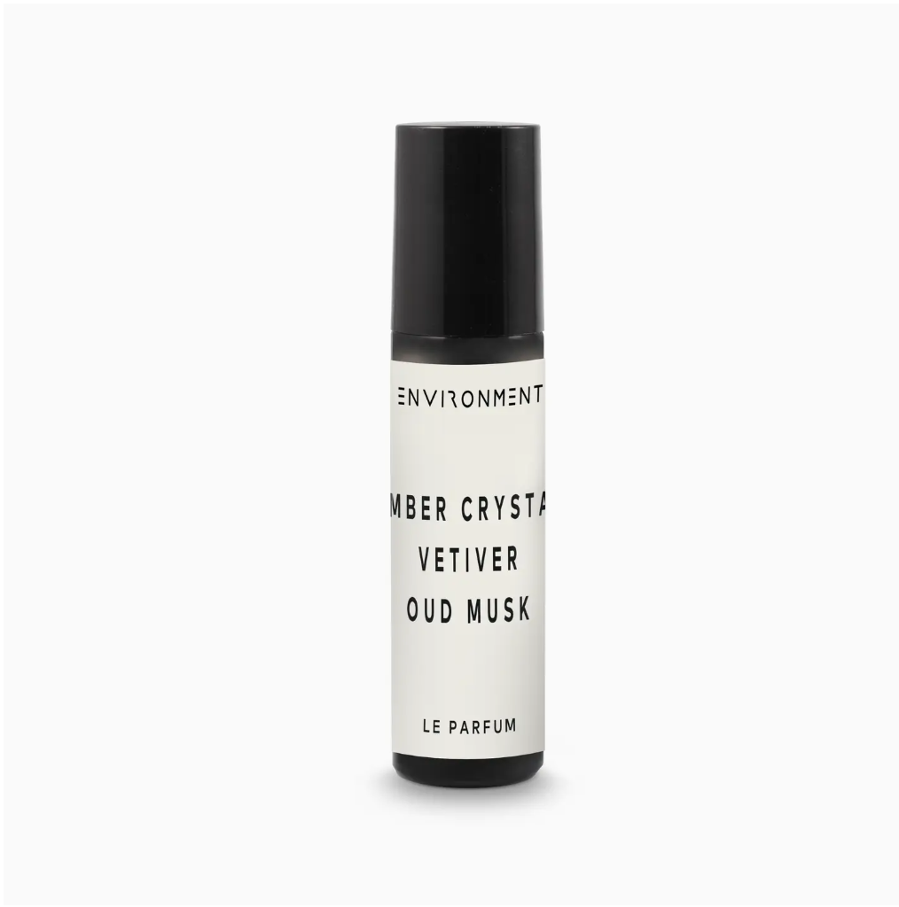 A black and white Inspired By Baccarat Rouge 540® Roll-On Amber Crystal | Vetiver perfume bottle labeled "Environment Amber Crystal, Vetiver, Oud Musk Le Parfum" against a plain white background in a Scottsdale, Arizona bungalow.