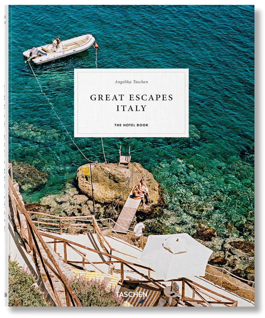Cover of "Great Escapes Italy" by Ingram Book Company. The image showcases a picturesque Amalfi Coast scene featuring a small boat on crystal-clear turquoise water, adjacent to a rocky shore and a wooden dock where sunbathers relax, capturing the essence of Italian lifestyle.