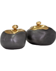 Two rounded, dark gray ceramic jars with golden lids, inspired by Scottsdale Arizona aesthetics, isolated on a white background. The Import Collection's Finkle Box.