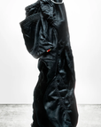 A puffy black winter coat stands upright on its own, seemingly filled with air. The coat's textural details and a small red tag marked "MADE IN USA" are visible against a white background.