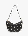A black leather crescent-shaped handbag named Lune by Clare Vivier, adorned with large silver studs. The bag features a single adjustable, knotted shoulder strap and gold-tone hardware for a chic and modern look. The background is white.