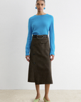 Rachel Comey Montrose Skirt in a modern style, shown on model with blue sweater and green shoes against white background.