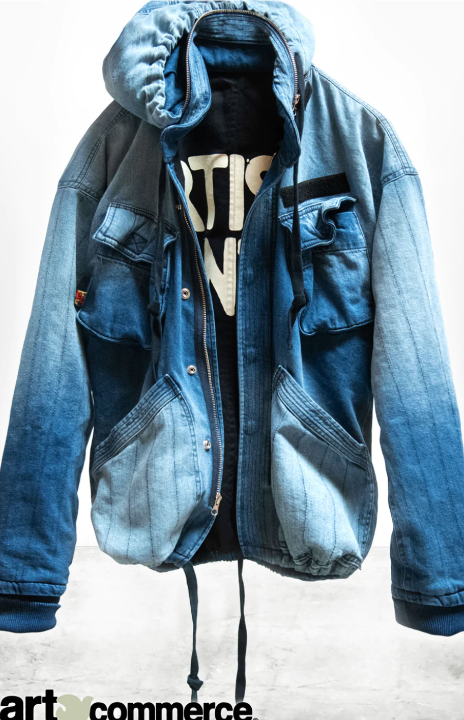 A structured display of a ARTISTSWANTED INDIGO ZIP HOOD jacket with a hood, worn over a black t-shirt with "ART" visible on it, against an Arizona-style background.