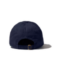 A navy blue, 100% cotton baseball cap with a back view showing an adjustable closure and brass buckle for customizing the fit. THE DROPOUT KAP NAVY, branded with "Kule," is set against a white background, casting a slight shadow to the right.