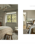 Two images of cozy, rustic bedrooms in a Scottsdale, Arizona bungalow with neutral color palettes. Left shows a bed with patterned bedding, a window, and a chair. Right features a bed with layered bedding and a small desk with a lamp from Call It Home: The Details That Matter by Random House.