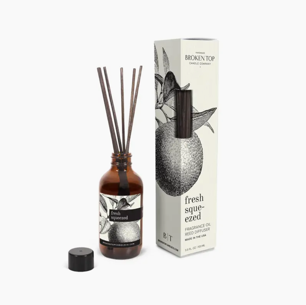 A Faire reed diffuser bottle with sticks and its packaging beside it, labeled &quot;Broken Top Candle Co., citrus scent fragrance oil reed diffuser.&quot; The packaging features a black and white citrus fruit illustration.