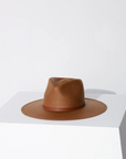 A Janessa Leone Sherman hat brown displayed on a white pedestal against a neutral background, showcasing Arizona style and detail in the design.