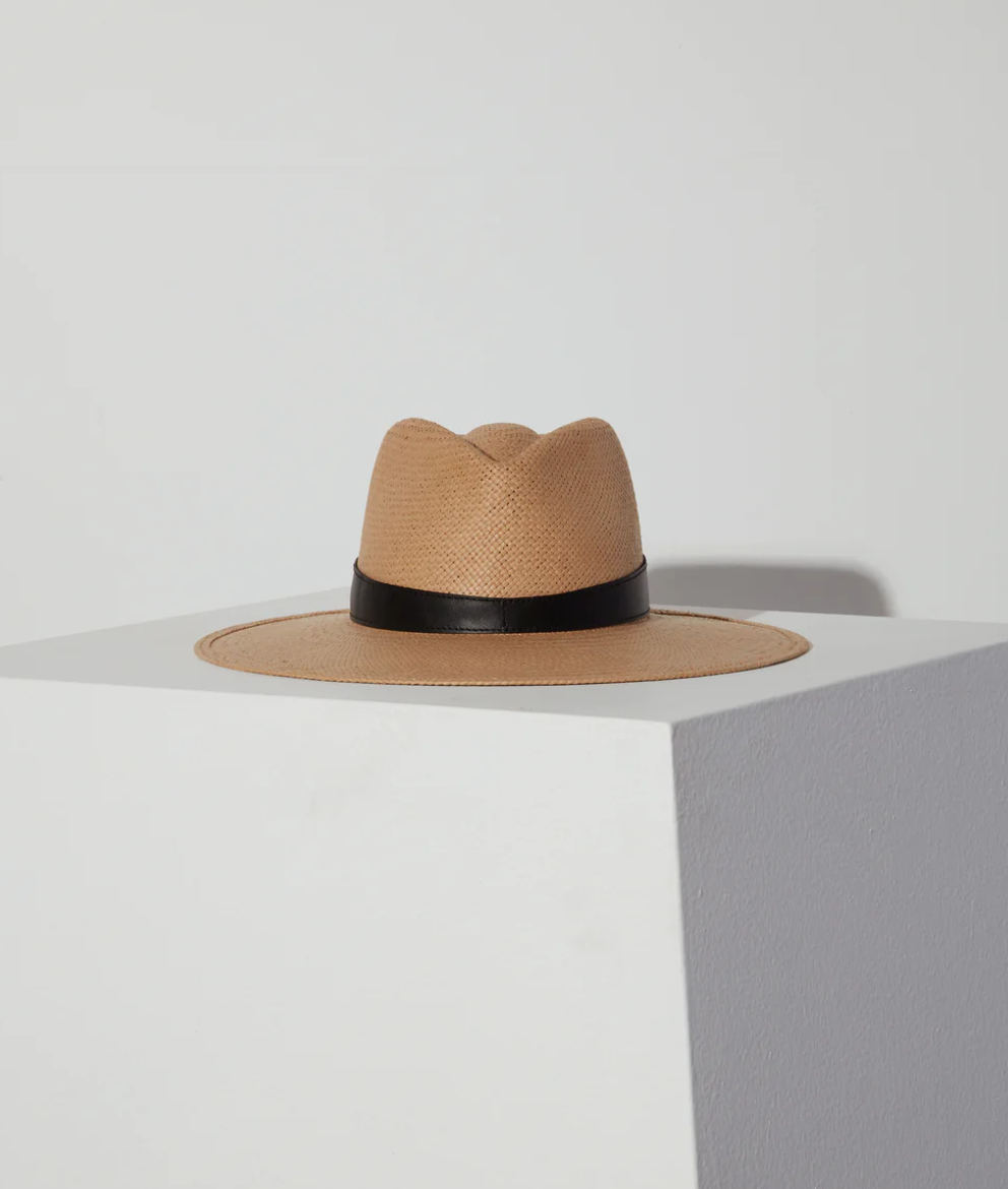 A Savannah hat sand with a black band, resting on a white shelf against a light gray background. The hat, exuding Arizona style, is positioned near the corner where the shelf meets the wall. (Janessa Leone)