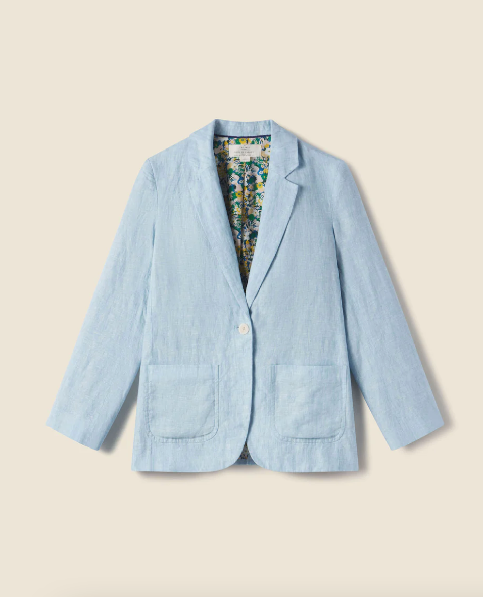 A THEO BLAZER SKY LINEN by Trovata, with a single white button and floral lining, displayed against an Arizona-style beige background.