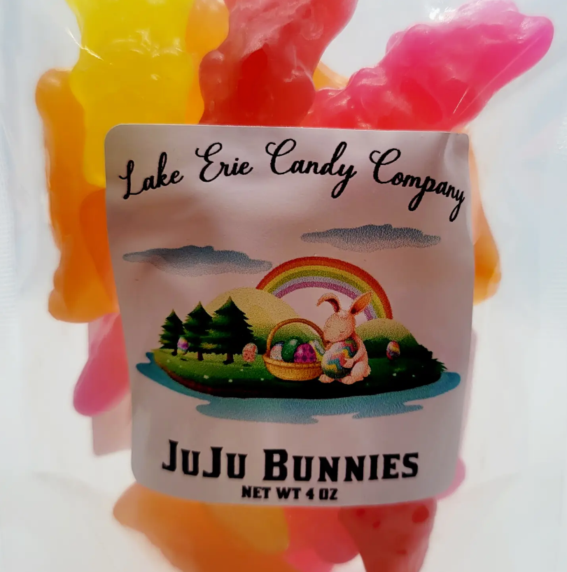 A package of Faire&#39;s Lake Erie Candy Assorted Easter Jelly Candy, featuring a colorful illustration of a bunny with a basket under a rainbow, surrounded by candy in bunny shapes at a charming bungalow.