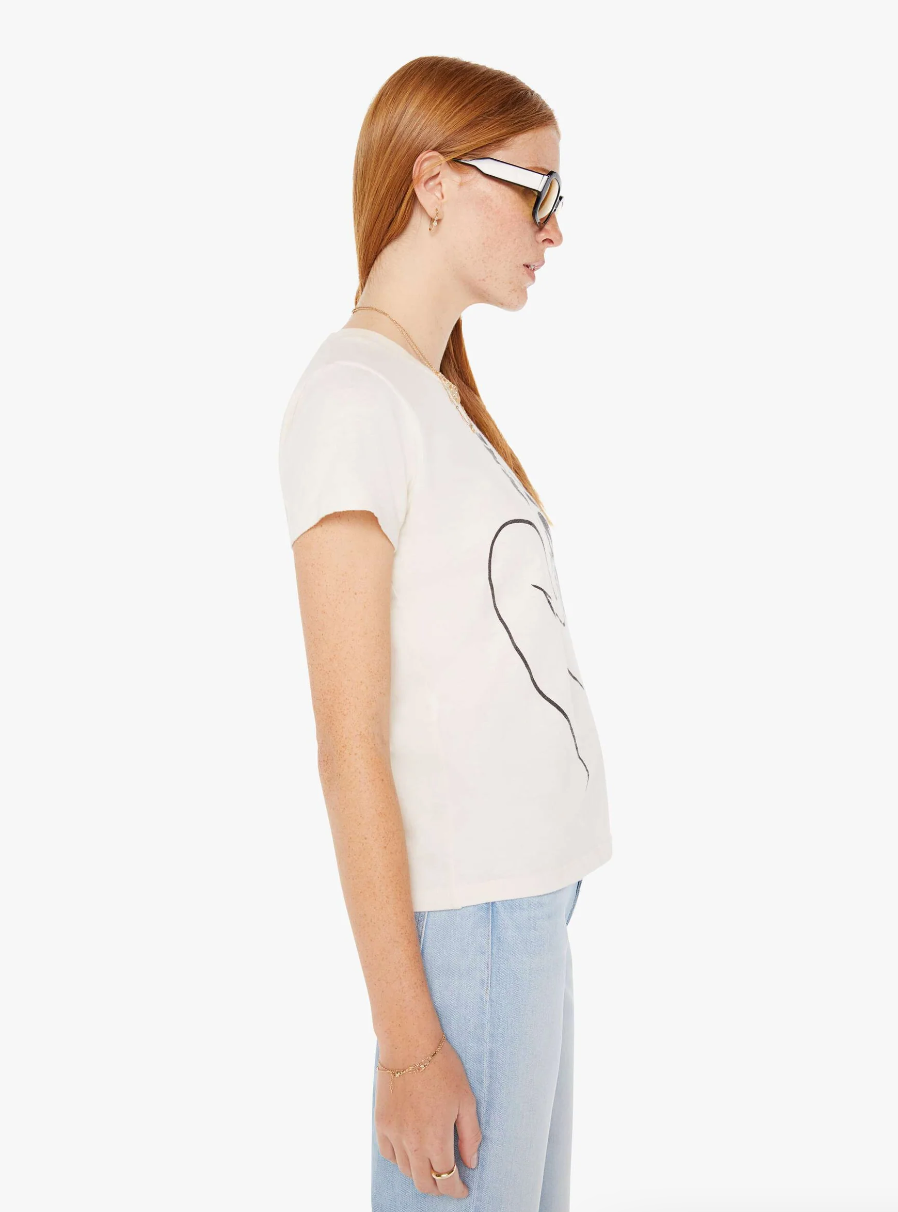Side profile of a woman with long red hair, wearing sunglasses, a white t-shirt with a black abstract design, and light blue jeans. She is facing to the left in Scottsdale, Arizona wearing The Sinful Femme Fatale by Mother.