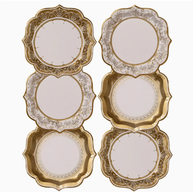 Six sets of Faire medium gold party plates with intricate patterns and different shapes, displayed against a white background in a Scottsdale, Arizona bungalow.