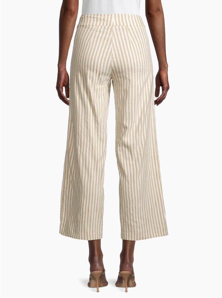 A person from the back wearing Avenue Montaigne's Alex Pant, cream and beige striped wide-leg trousers paired with beige high-heeled sandals, reminiscent of a chic bungalow style in Scottsdale, Arizona.
